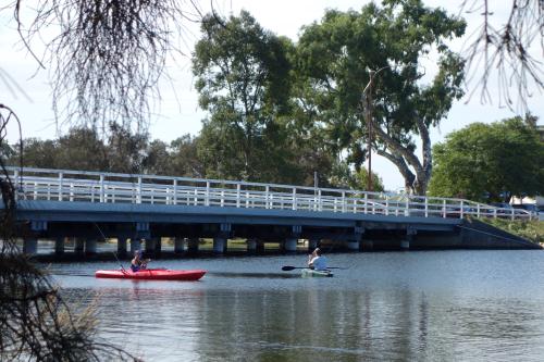 Bridge across the river with kayakers paddling underneath.