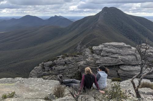 Two people on the summit of Talyuberlup, with Mount Magog in the distance